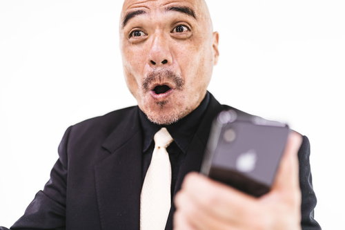 サプライズで大喜びする中年男性のスマートフォン反応