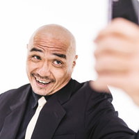 自撮り画像を送るスキンヘッドの強面中年男性の写真