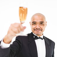 シャンパングラスを片手に乾杯する紳士的な男性の写真