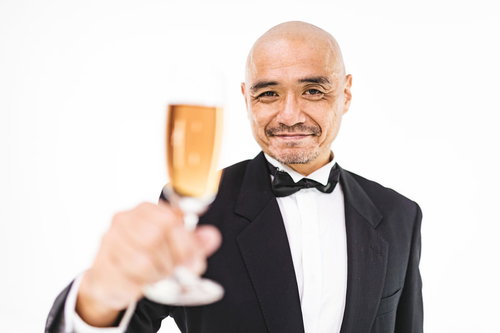 フォークで乾杯をするスキンヘッドの中年の紳士