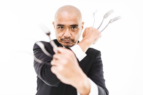フォークで武装する強面執事、スキンヘッドの男性