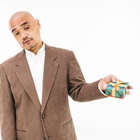 嫌々プレゼントを渡す中年男性のスキンヘッドの写真