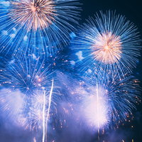 夜空に白と金色の光が放射状に広がる花火大会の打ち上げ花火の写真