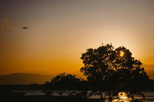 夕暮れの木曽川と赤く染まる空を行く訓練中のC-1輸送機のシルエット