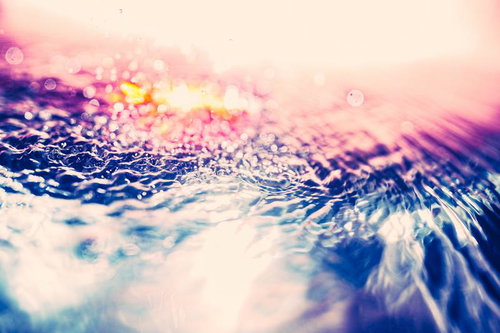 淡いピンクの光に包まれた水面の波紋