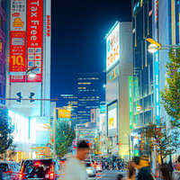 新宿東口付近の夜間繁華街のネオン看板と交差点の写真
