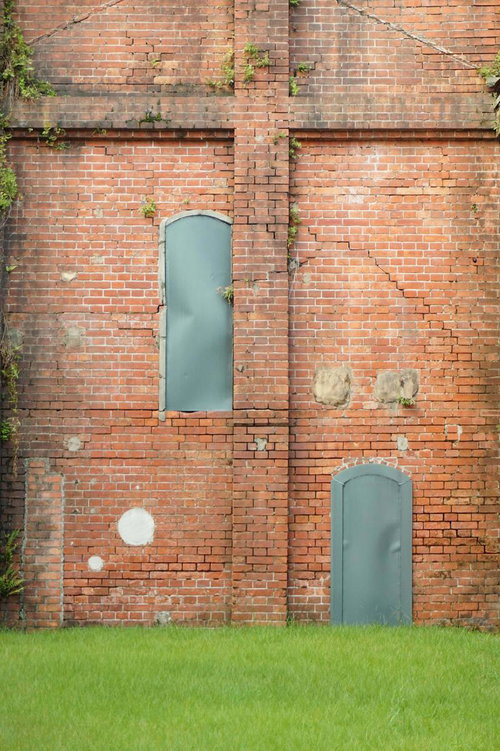 経年変化したレンガ壁に設置された青緑色の扉