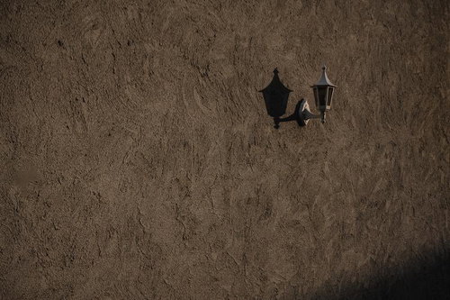 無機質な壁に取り付けたレトロなランプの影