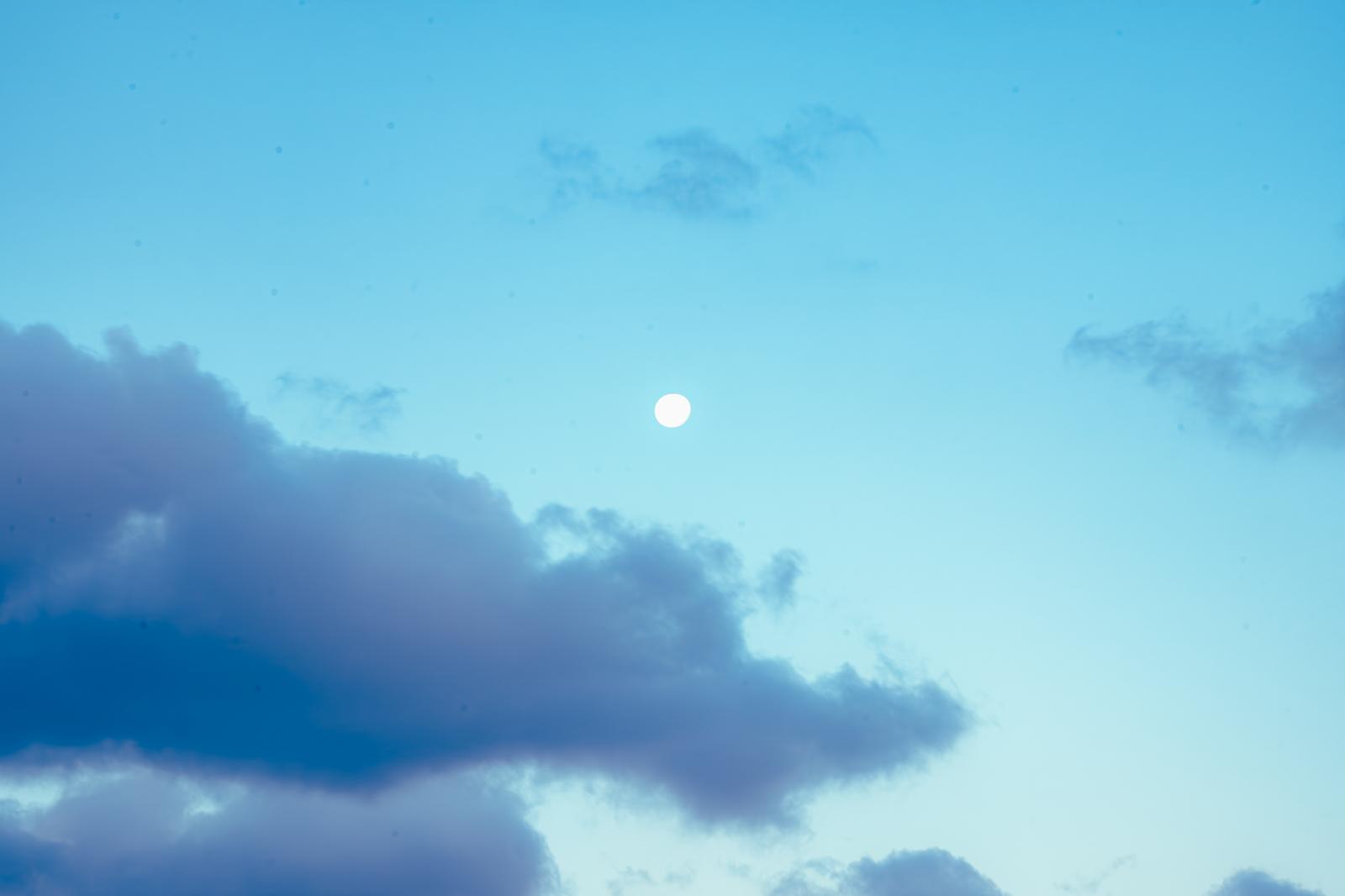 かたわれ時の月と朝焼けが映る青い空と積雲
