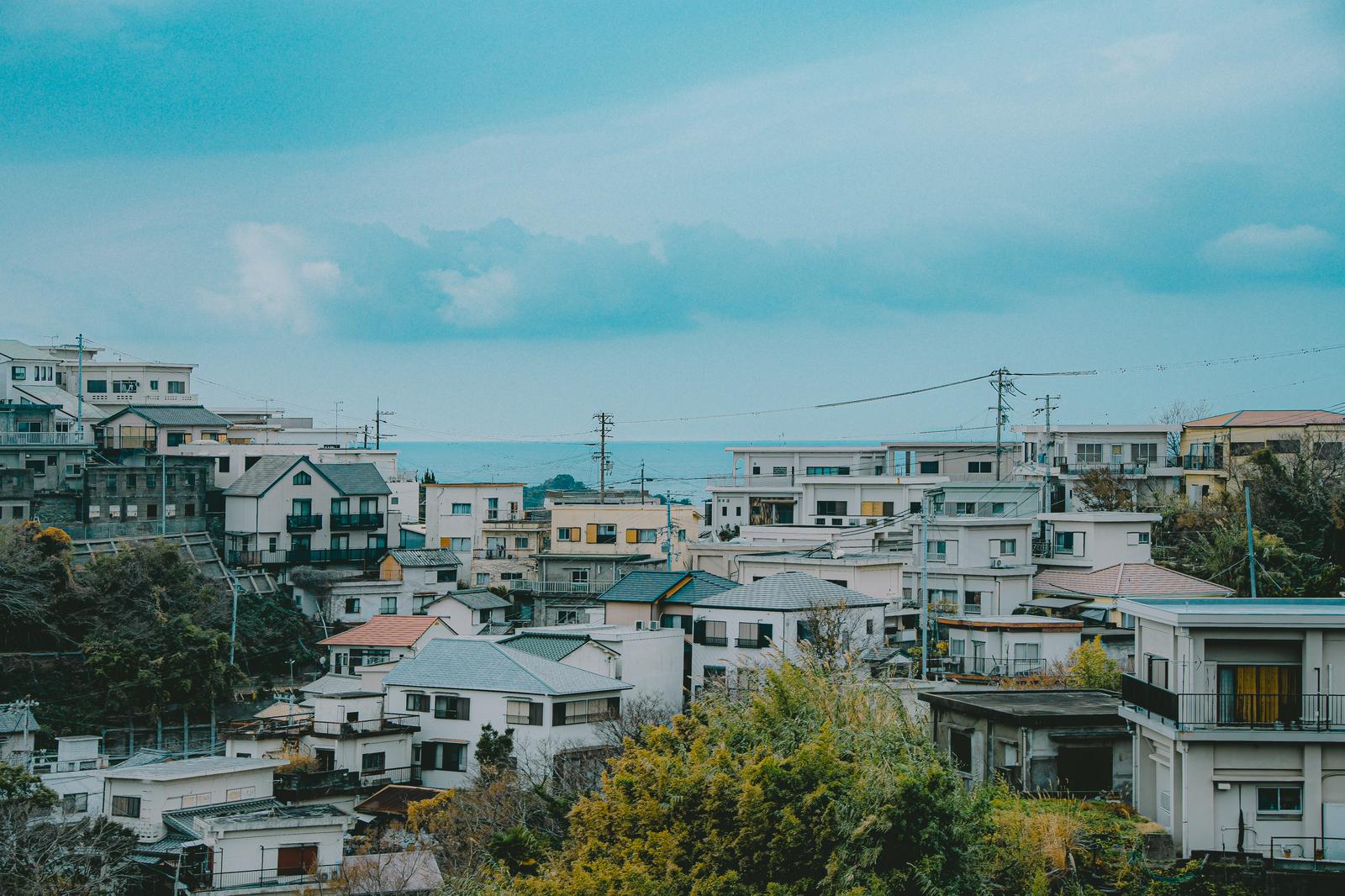 和歌山県の雑賀崎の町並みと海の景観。住宅が密集した港町を上空から俯瞰した風景