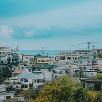 遠くに見える海と雑賀崎の町並み、電柱と瓦屋根の港町風景の写真