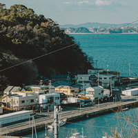 穏やかな海と山に囲まれた塩津港の街並みと漁船の写真