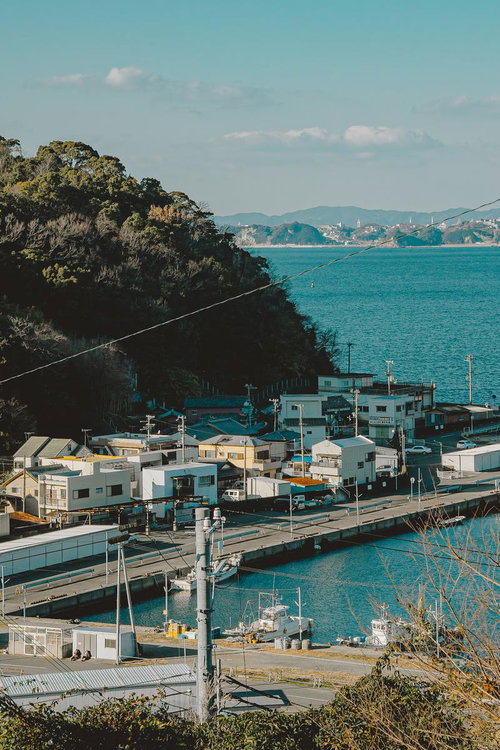 穏やかな海と山に囲まれた塩津港の街並みと漁船