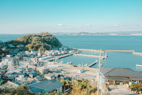 青空の下、山と海に囲まれた塩津漁港の風景