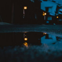 水たまりに映り込む妻籠宿の灯り、暗い路地を彩る夕闇の写真