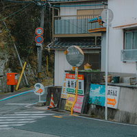 カーブミラーや「飛び出し注意」の看板が設置された路地の写真