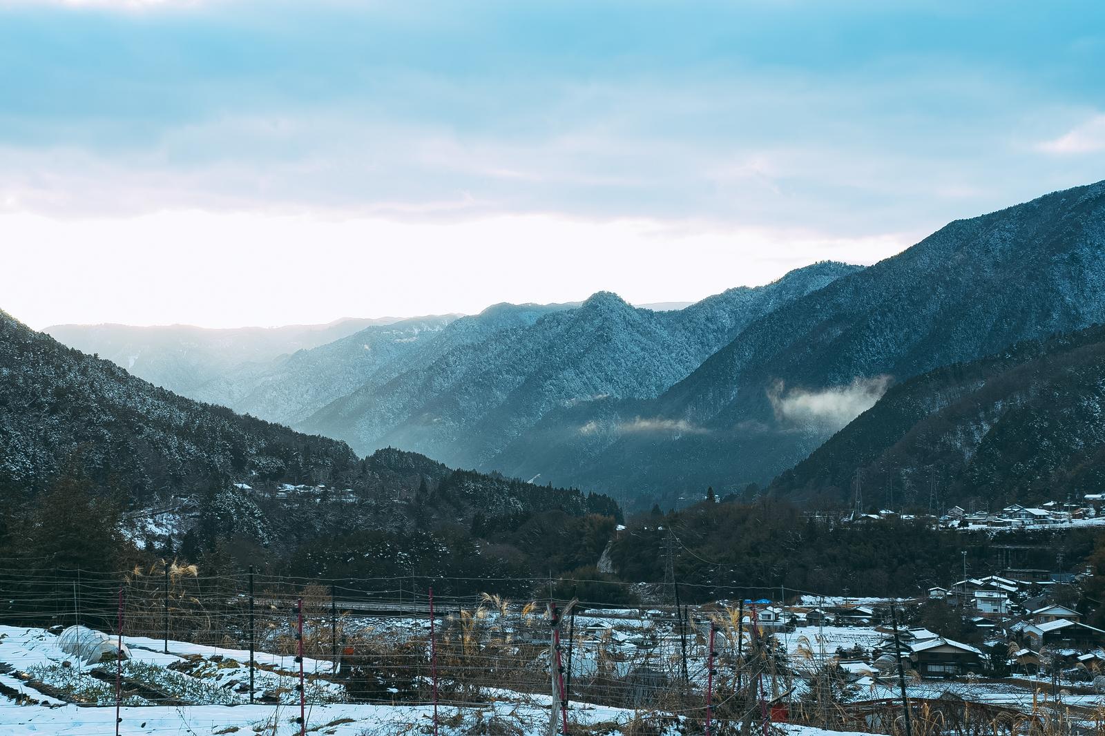 雪化粧した山々に囲まれた長野県大桑村の冬の集落風景