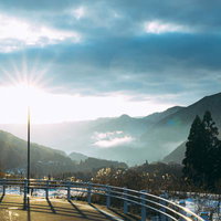 長野県大桑村からの夕暮れの景色、光芒が差す山間の道路の写真