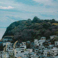 海風が吹き抜ける和歌山市雑賀崎の住宅地と緑の丘の写真
