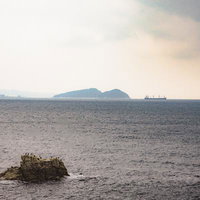 和歌山県の海沿いから見える岩と船、水平線の写真
