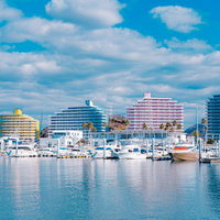 青空に映える和歌山マリーナシティのヨットハーバーと高層ホテルの写真