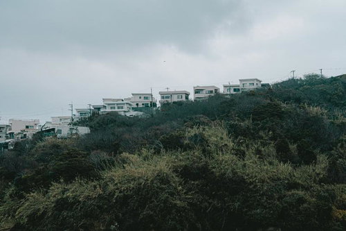 曇天の丘陵地に建ち並ぶ住宅群と階段状の造成地