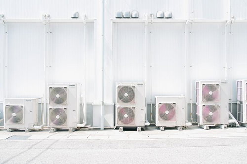 建物外壁に並ぶエアコン室外機の整列風景