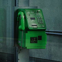 電話ボックスの内部に設置された公衆電話（緑）の写真