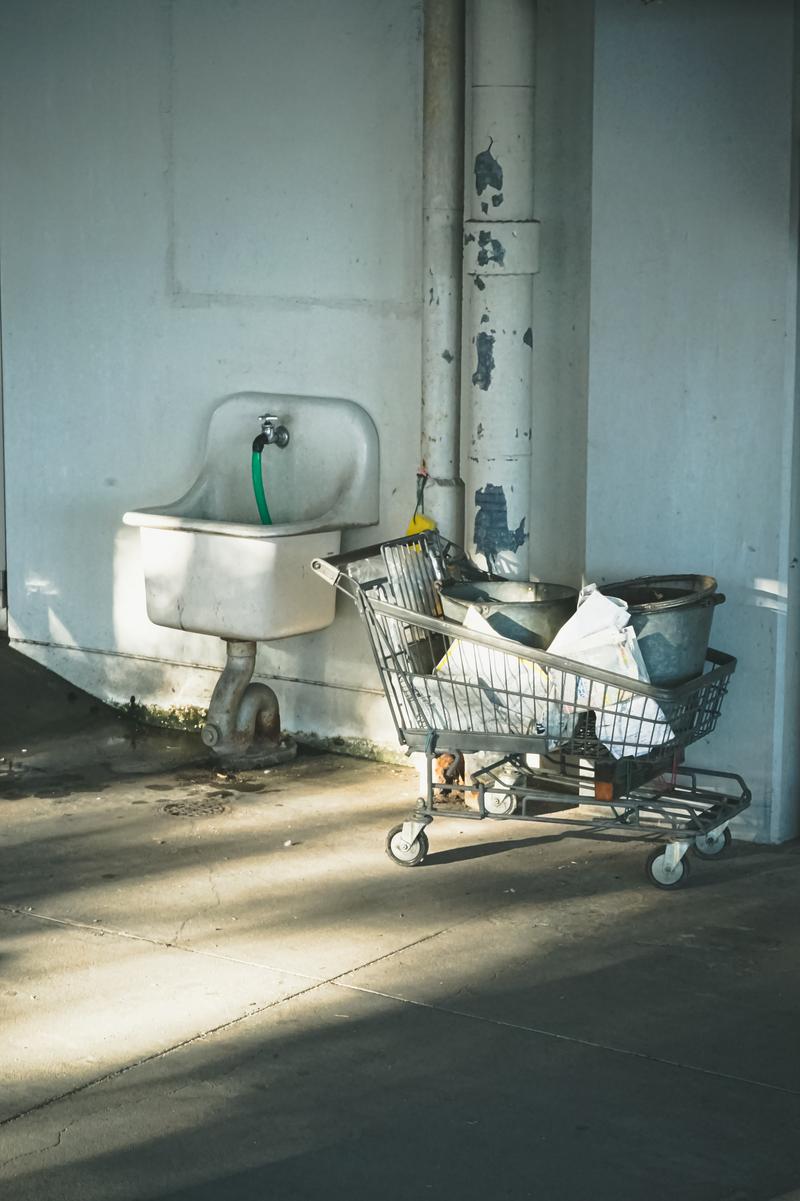 壁沿いに並ぶ古い流し台とショッピングカート