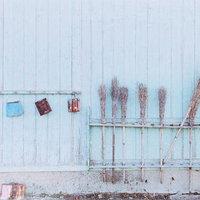 古民家の軒先に掛けられた箒や道具の写真