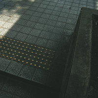 公園のアスファルトに敷設された点字ブロックの写真
