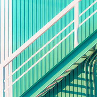 エメラルド色の金属階段と白い手すり、モダンな建築デザインの写真