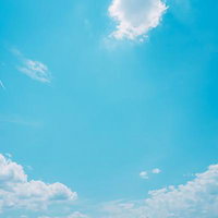 快晴の青空に白い積雲と飛行機雲が浮かぶ空の写真