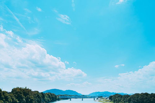 青空と白い雲が流れる川と橋の自然風景