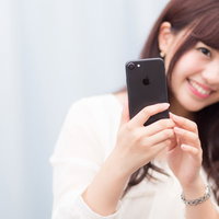 黒いスマートフォンは大人っぽい？笑顔の女性の写真