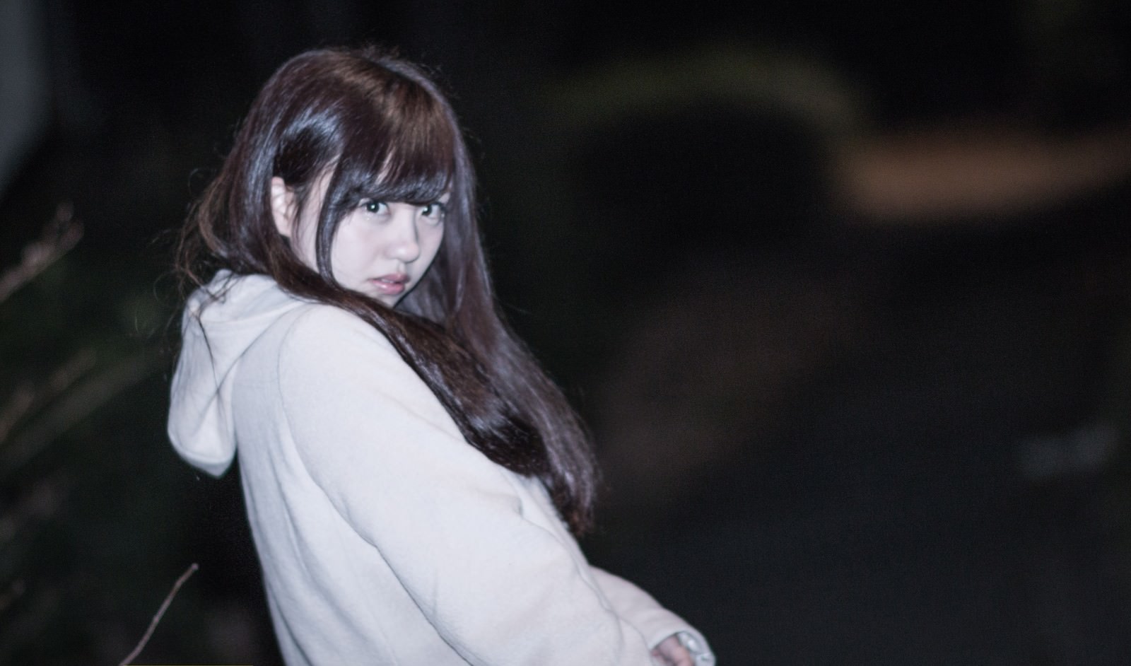 夜間に振り返えった瞬間、フラッシュで驚く女性の表情［モデル：河村友歌］