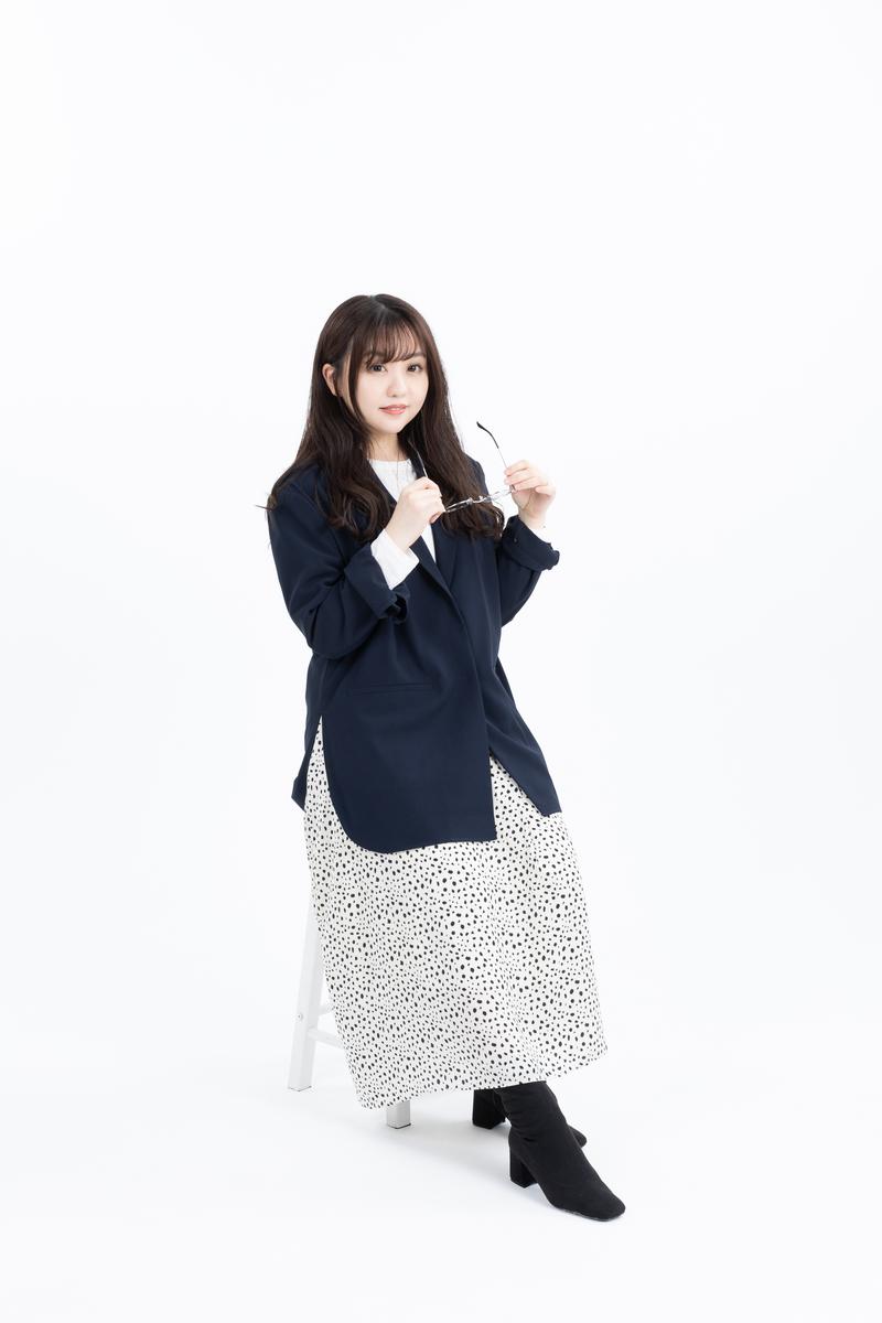 メガネを外してチラ見する紺色ブレザーの女性［モデル：河村友歌］