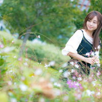 お花摘みにきた庭で花壇の前でしゃがむ女性の写真