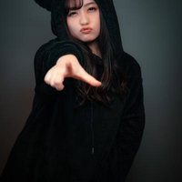 凄いやる気のない整体師に当たった。くまさん耳のフード姿で指を指す女性の写真