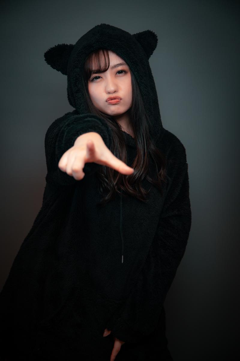 くまさん耳フード姿で指を指す女性が指摘する表情［モデル：河村友歌］