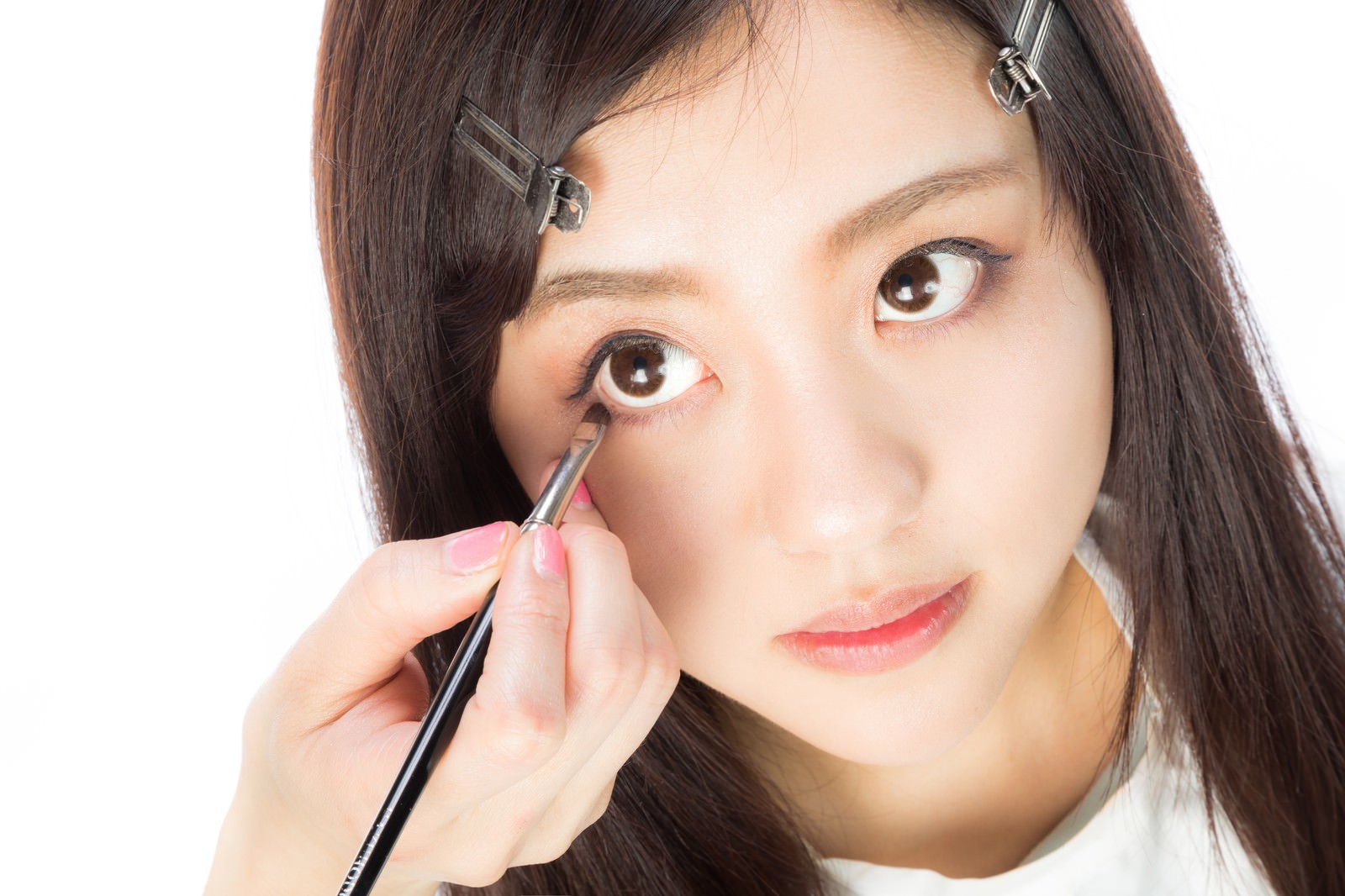 メイクブラシで下瞼にアイシャドウを塗っている女性［モデル：河村友歌］