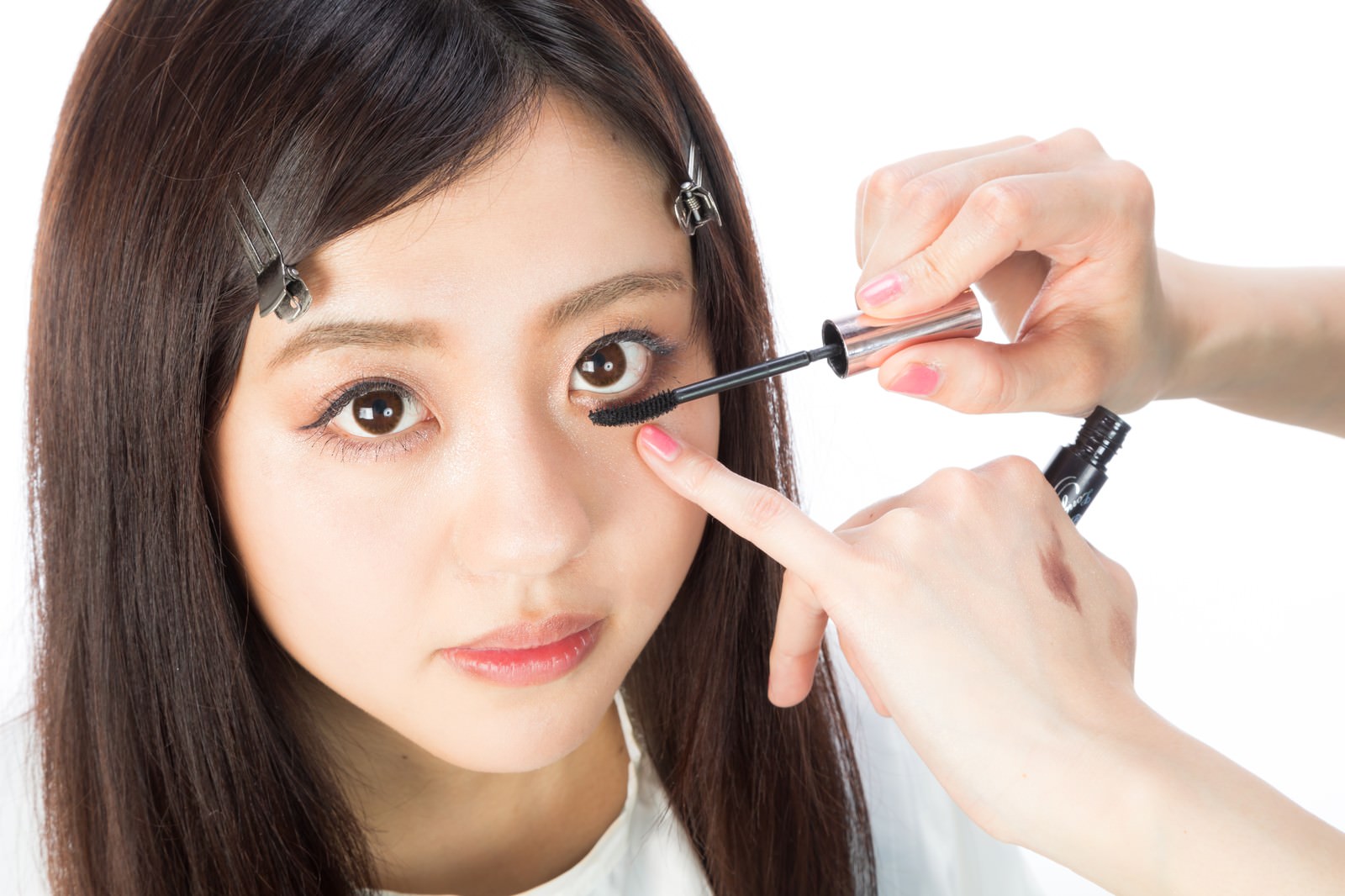 下まつ毛にマスカラを塗ってもらっている女性［モデル：河村友歌］