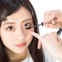 下まつ毛にマスカラを塗る女性のメイクアップの写真