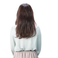 ライトグリーンのトップスを着たサロンモデルの後ろ姿の写真