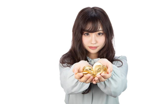 両手いっぱいに広げたビットコインを持つ女性