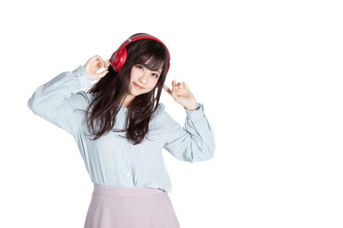 赤いヘッドフォンで音楽を聞きながらリズムに乗る女性