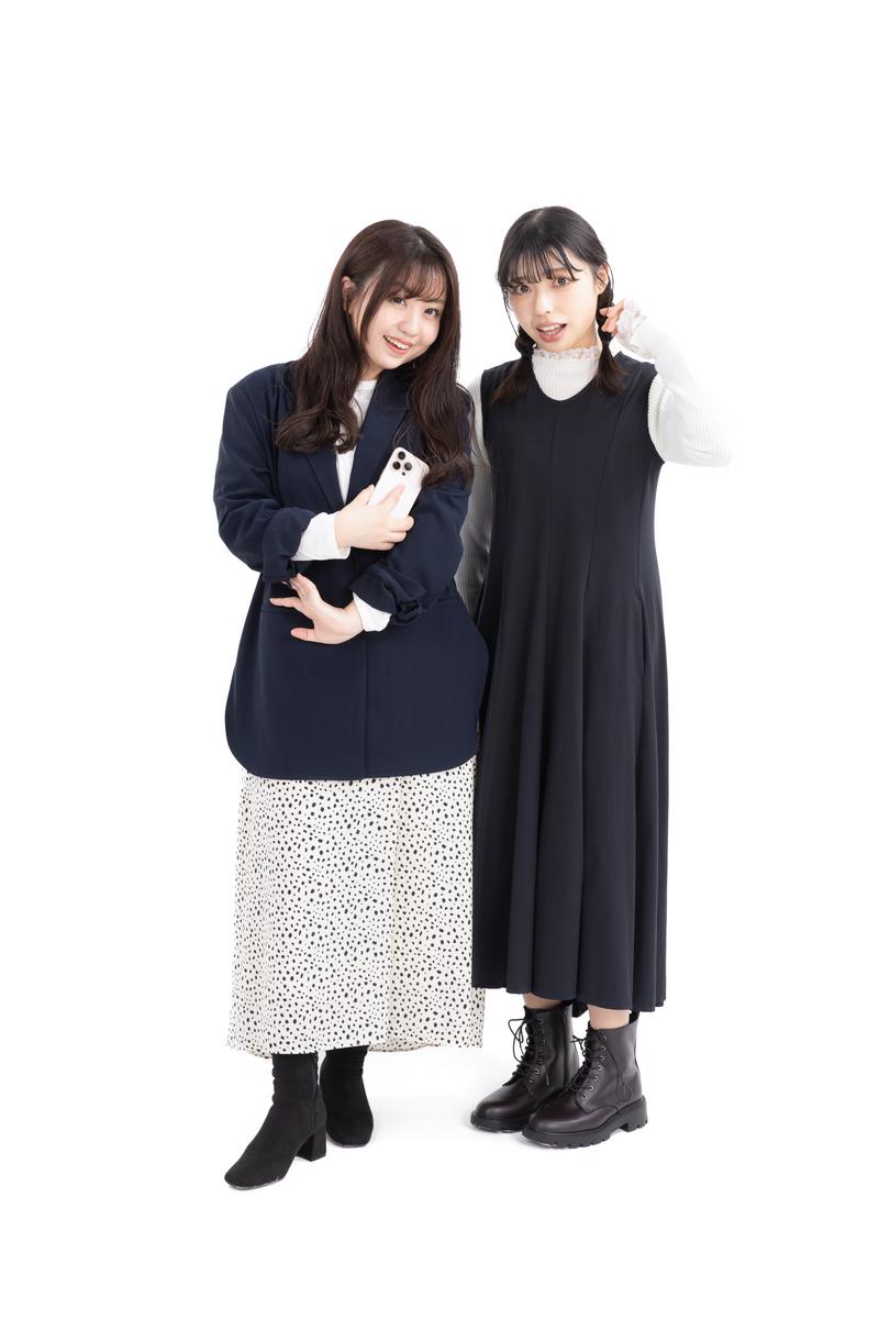 スマートフォンを持つ紺ジャケットの女性と、黒いワンピース姿の女性が笑顔で並ぶ［モデル：河村友歌 高尾実生］