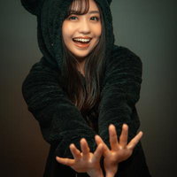 黒猫フードを被った笑顔で両手を広げる女性の写真