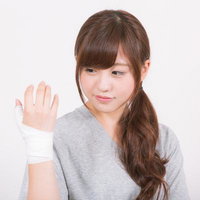 利き手の示指を包帯で固定する女性の手指固定治療の写真