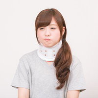 交通事故で頚椎カラーを装着した女性の治療中の姿勢の写真